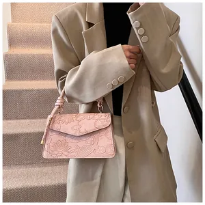 Detail of pink embossed handbag with lotus pattern and unique knotted leather handle