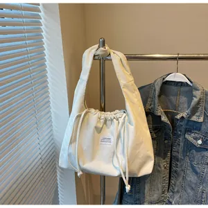 Vue détaillée du sac seau en velours côtelé blanc cassé avec cordon et étiquette