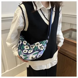 Crescent floral crossbody bag with blue adjustable strap shown on model in a modern style