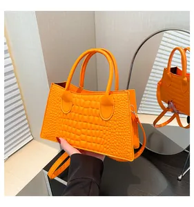 Dettaglio della texture a coccodrillo arancione su borsa a trapezio retrò strutturata