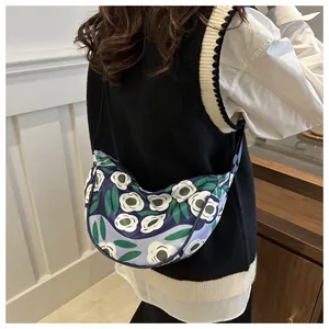 Detail of floral dumpling crossbody bag with camellia pattern and adjustable strap