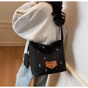 Detail der schwarzen Canvas-Tasche mit bunter Stickerei und passendem Mini-Beutel