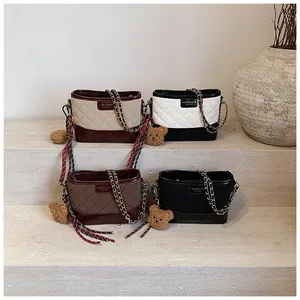Détail de quatre sacs à bandoulière matelassés avec chaînes dorées et pendentif ours