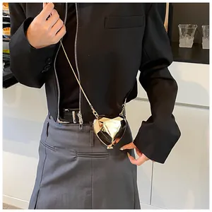 Detail of geometric heart-shaped crossbody bag with gold mirror finish and chain strap