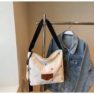 Detailaufnahme der weißen Canvas-Einkaufstasche mit Stickerei und kleinem Zusatzbeutel