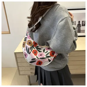 Detail of hobo bag featuring vibrant floral patterns and wide fabric shoulder strap
