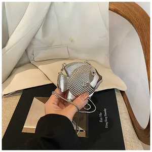 Makro-Detail der silbernen Fisch-Clutch mit funkelnden Strasssteinen und Metallkette