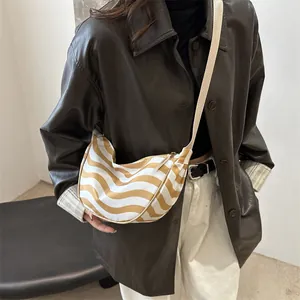 Chic crescent-shaped canvas crossbody bag with yellow wave stripes and fabric strap