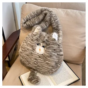 Detail der grauen Plüschtasche in Katzenform auf einem beigen Sessel mit einem Buch
