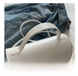 Detail der weißen PU-Leder Handtasche mit weichem Griff und goldener Metallschnalle