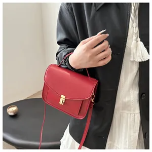 Detail der roten Ledertasche mit goldener Metallschnalle und praktischem Handgriff