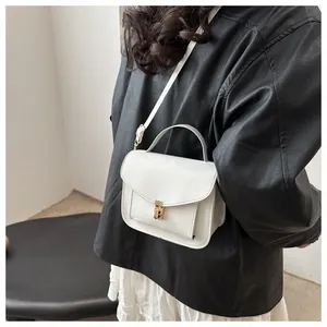 Details einer weißen Mini-Umhängetasche aus Leder mit goldener Schnalle