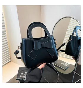 Elegante borsa a mano in pelle opaca nera con grande fiocco decorativo e tracolla