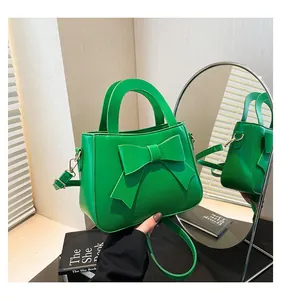 Elegante borsa a tracolla verde con grande fiocco e dettagli in oro lucido
