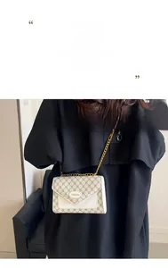 Détail du sac bandoulière vintage à motifs avec chaîne dorée et plaque logo en métal