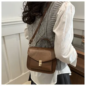 Detailansicht einer braunen Vintage-Leder-Umhängetasche mit goldener Schnalle und Griff