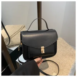 Detailaufnahme der schwarzen Vintage-Handtasche mit goldenem Drehverschluss aus Leder