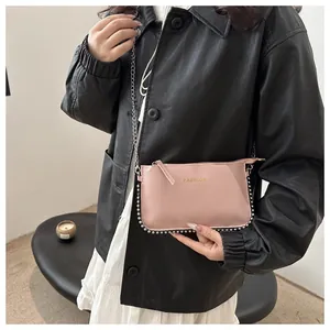 Detail of pink fashion envelope bag with silver bead trim and metal chain strap