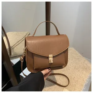 Detailansicht der braunen Vintage-Tasche mit goldenem Drehverschluss und Ledertextur