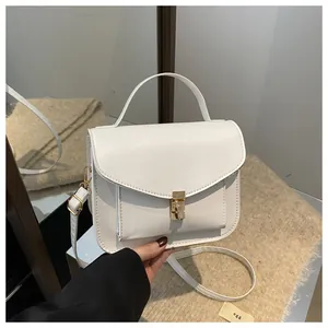 Detailansicht der weißen Ledertasche mit elegantem goldenem Metalldruckverschluss
