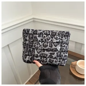 Close-up of a stylish leopard print quilted clutch bag with soft texture and chic pattern