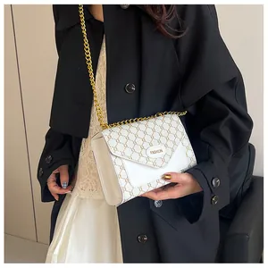 Détail du sac bandoulière vintage avec motif monogramme et chaîne dorée élégante