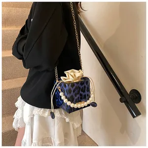 Blue leopard print bucket bag featuring luxury pearl handle and gold chain detail