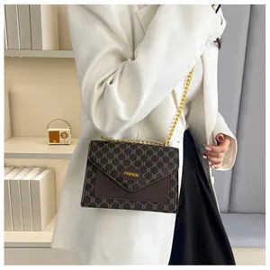 Détail d'un sac bandoulière vintage avec chaîne dorée et motif élégant imprimé