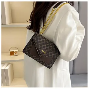 Détail du sac monogramme marron vintage avec chaîne dorée porté par un mannequin