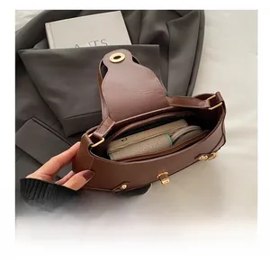 Internal view of brown leather crescent bag showing phone storage and zip pocket