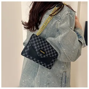 Détail du sac à rabat bleu marine vintage avec chaîne dorée et étiquette en cuir chic
