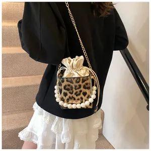 Fashionable leopard print bucket bag with pearl handle and gold chain strap on model
