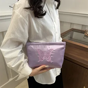 Borsa cosmetica in raso viola con ricamo a farfalla e manico elegante