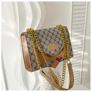Détail de sac bandoulière vintage avec motif géométrique gris et chaîne dorée
