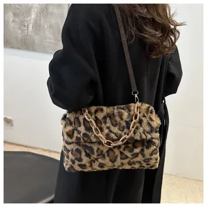 Dettaglio della borsa a tracolla leopardata in peluche con catena su cappotto nero