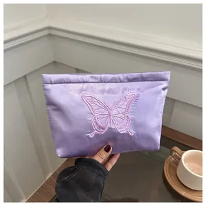 Kosmetiktasche aus lila Satin mit eleganter Schmetterlingsstickerei für unterwegs