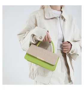 Détail du sac à main vert et paille avec boucle de fermeture horizontale en métal doré