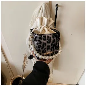 Detail of leopard print bucket bag with faux pearl handle and gold chain strap