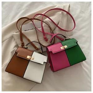 Detalle de bolso Kelly bicolor con cierre de metal sobre fondo de chaqueta elegante