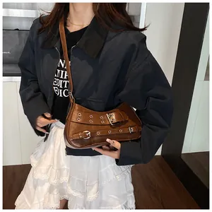 Brown vintage faux leather underarm bag with metal eyelets and adjustable buckle strap