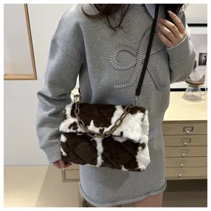 Détail du sac bandoulière en peluche à motif vache avec matelassage et chaîne en résine