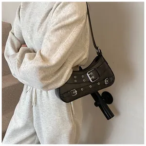 Detail view of a matte faux leather shoulder bag with silver metallic buckle decorations