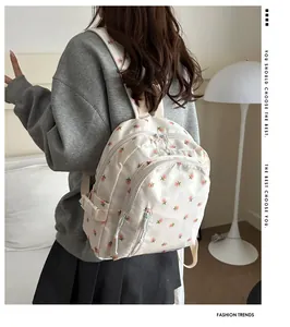 Detail of cute beige floral backpack with multiple zippered pockets and adjustable straps