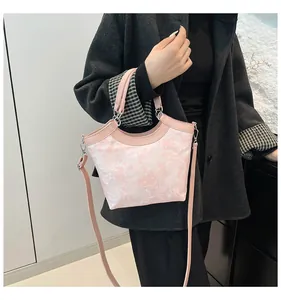 Detail of pink jacquard fabric tote bag with leather straps on a fashion model
