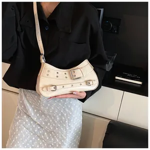 Detail of cream PU leather shoulder bag featuring vintage metallic eyelets and buckles