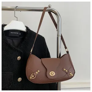 Detail of a brown crescent shoulder bag with golden twist lock and rivet leather straps