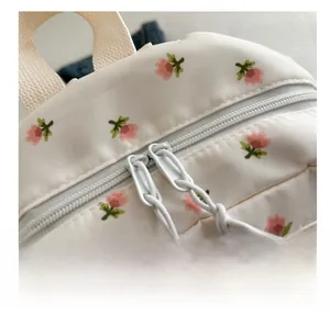 Detail shot of smooth double-way zippers on floral print backpack with woven pullers
