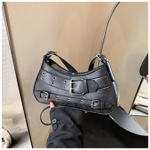 Detail of black punk Y2K crescent bag with silver eyelets and metal buckle straps