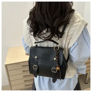Detailansicht des schwarzen Vintage-PU-Rucksacks mit Goldschnallen und Logo am Model
