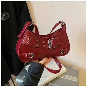 Detail of burgundy PU leather shoulder bag with silver metallic buckle and rivets